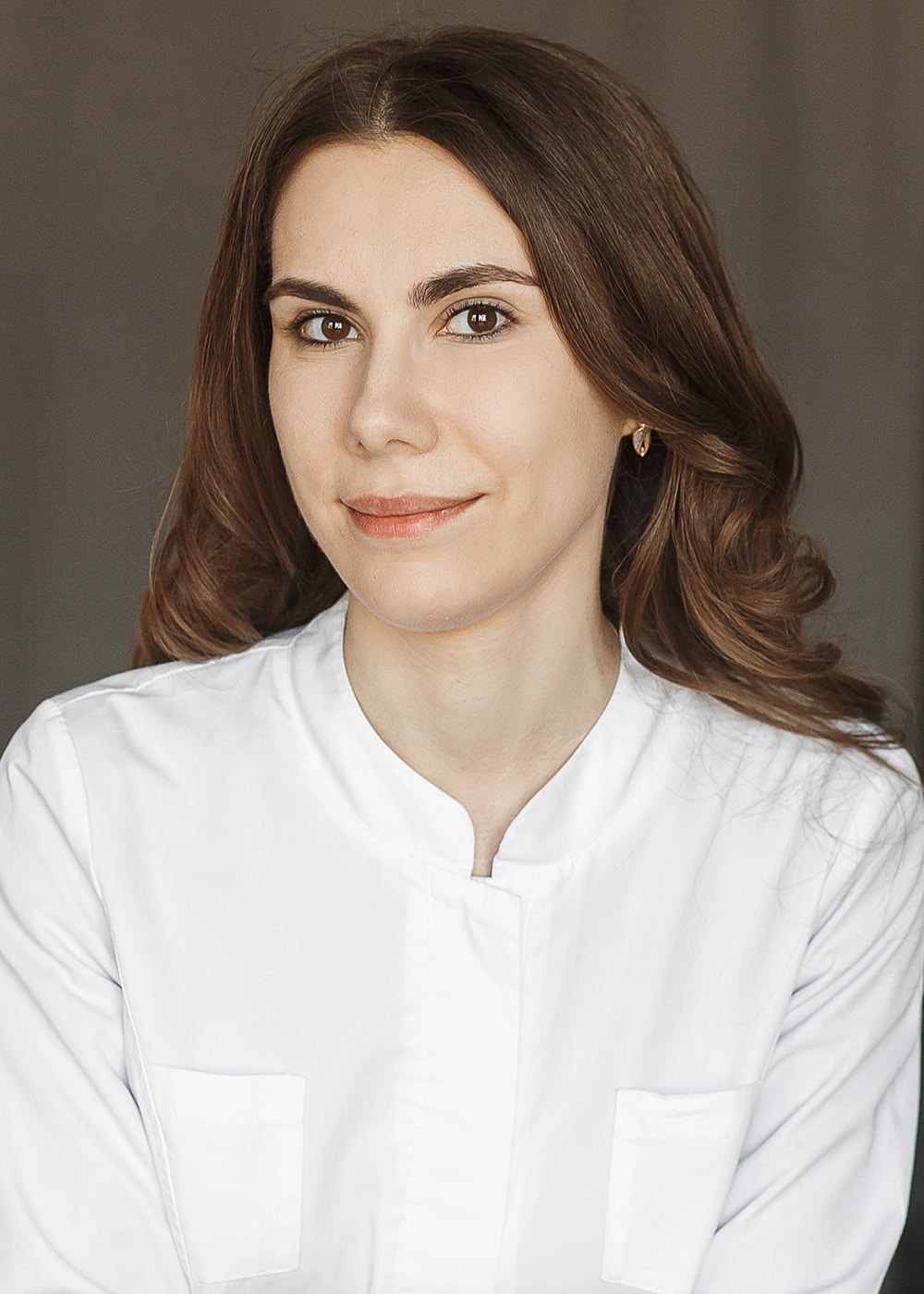 Professional woman in a white shirt, smiling.